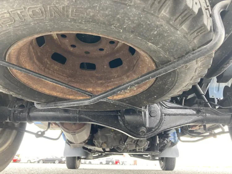 Rusty spare wheel and rear axle under a Daihatsu Hijet Kei Truck