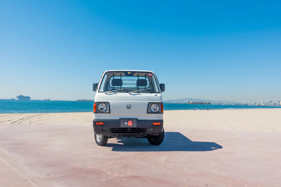 Front view of a white Honda Acty Kei Truck parked on the beach