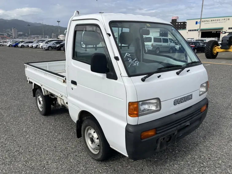 White 1990s Suzuki Carry DD51T 4WD Kei Truck at a Japanese vehicle port